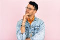 Studio portrait of a handsome thoughtful young man  thinking an idea posing over isolated pink background. Male wearing stylish Royalty Free Stock Photo