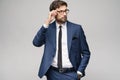 Portrait of a handsome young stylish businessman wearing glasses over grey background Royalty Free Stock Photo