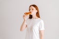 Studio portrait of happy attractive young woman with closed eyes appetite eating delicious pizza standing on white Royalty Free Stock Photo