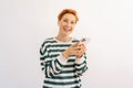 Studio portrait of happy attractive young woman wearing casual clothes standing using mobile cell phone typing sms Royalty Free Stock Photo
