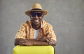 Studio portrait of happy black tourist in hat and sunglasses with his travel suitcase Royalty Free Stock Photo