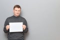 Portrait of happy man holding white blank paper sheet in hands Royalty Free Stock Photo