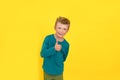 Studio portrait of happy boy showing thumb up gesture, yellow background. Royalty Free Stock Photo