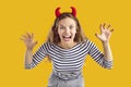 Studio portrait of happy funny young girl wearing devil horns as her Halloween costume Royalty Free Stock Photo