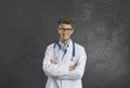 Studio portrait of happy male doctor standing with arms folded and smiling at camera Royalty Free Stock Photo