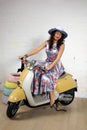 Studio portrait of a happy young asian woman on scooter Royalty Free Stock Photo