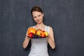 Portrait of happy young woman holding plate of ripe fresh fruits