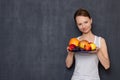 Portrait of happy young woman holding plate of ripe fresh fruits