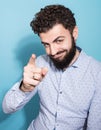 Studio portrait of happy young man pointing finger at camera Royalty Free Stock Photo