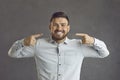 Studio portrait of a happy young man pointing at his broad smile with perfect white teeth Royalty Free Stock Photo