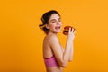 Studio portrait of hungry european girl. Good-looking woman eating cheeseburger