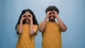 Studio portrait Indian family Arabian couple Hispanic man woman looking through hands make circles shape binoculars Royalty Free Stock Photo