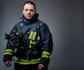 Studio portrait of a male dressed in a firefighter uniform.