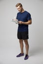 Studio Portrait Of Male Sports Coach With Clipboard