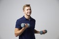 Studio Portrait Of Male Sports Coach Holding Weights