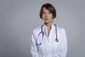 Studio portrait of middle aged female doctor against isolated background Royalty Free Stock Photo