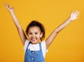 Studio portrait mixed race girl showing surprise with her hands raised isolated against a yellow background. Cute Royalty Free Stock Photo