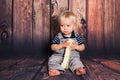 One year old baby boy sitting on chair in front of wooden background. One year concept with copy space Royalty Free Stock Photo