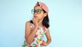 Studio portrait of a pensive child wearing colorful dress, pink cap, and eyeglasees looking at one side posing over light blue Royalty Free Stock Photo