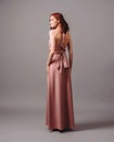 Bridesmaid's look. Studio portrait of pensive ginger glamour young woman in pink halter dress