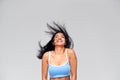 Studio Portrait Of Positive Happy Young Woman Flicking Long Hair