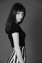 Studio portrait of a young woman against plain black background