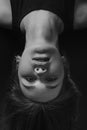 Studio portrait of pretty brunette woman upside down on black background. Black and white Royalty Free Stock Photo