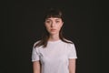 Studio portrait of a young woman against plain black background