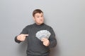 Portrait of proud confident mature man pointing at money