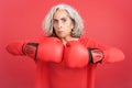 Rude mature woman in boxing gloves looking at camera Royalty Free Stock Photo