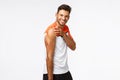 Studio portrait sassy, masculine handsome sportsman in activewear raise t-shirt sleeve and tense muscles, showing strong