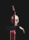 Studio portrait of senior man with guitar