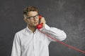 Studio portrait of serious focused man talking on landline phone and looking up thoughtfully.