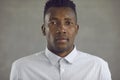 Studio portrait of serious young African-American man in white shirt looking at camera Royalty Free Stock Photo