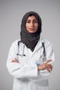 Studio Portrait Of Serious Young Doctor With Headscarf Wearing White Coat Against Plain Background Royalty Free Stock Photo