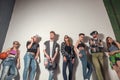 Studio portrait of seven young fashion attractive smiling caucasian women and men friends dressed jeans group together
