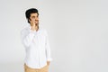 Studio portrait of smiling bearded young man talking smartphone, having conversation on mobile phone, holding and using Royalty Free Stock Photo