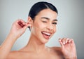 Studio portrait of a smiling mixed race young woman with glowing skin posing against grey copyspace background while Royalty Free Stock Photo