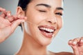 Studio portrait of a smiling mixed race young woman with glowing skin posing against grey copyspace background while Royalty Free Stock Photo