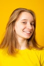 Studio portrait of a smiling teenage girl on a yellow background Royalty Free Stock Photo