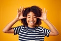 Studio Portrait Of Smiling Young Boy Pulling Funny Face Shot Against Yellow Background Royalty Free Stock Photo