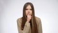 Studio portrait of teenage girl holding finger at mouth at shhh gesture