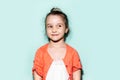 Studio portrait of thoughtful funny little child girl, looking up, wearing coral pink shirt on background of cyan, aqua menthe. Royalty Free Stock Photo