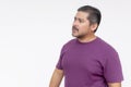 Studio portrait of a thoughtful middle-aged man in a purple shirt looking to the side against a white background Royalty Free Stock Photo