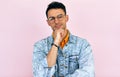 Studio portrait of a thoughtful young man thinking an idea posing over isolated pink background. Male wearing stylish casual Royalty Free Stock Photo