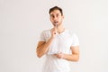 Studio portrait of thoughtful young man writing in copybook touching chin on white isolated background. Royalty Free Stock Photo