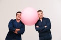 Two men posing with big pink ball Royalty Free Stock Photo