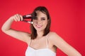 Studio portrait of a woman applying cosmetic tonal foundation on face using makeup brush. Beautiful girl doing