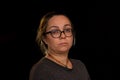 Studio portrait of a woman with glasses on a dark background Royalty Free Stock Photo