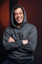 Studio portrait of a 40-50-year-old laughing man in a gray hoodie on a neutral background with a hood on his head, looking away. M Royalty Free Stock Photo